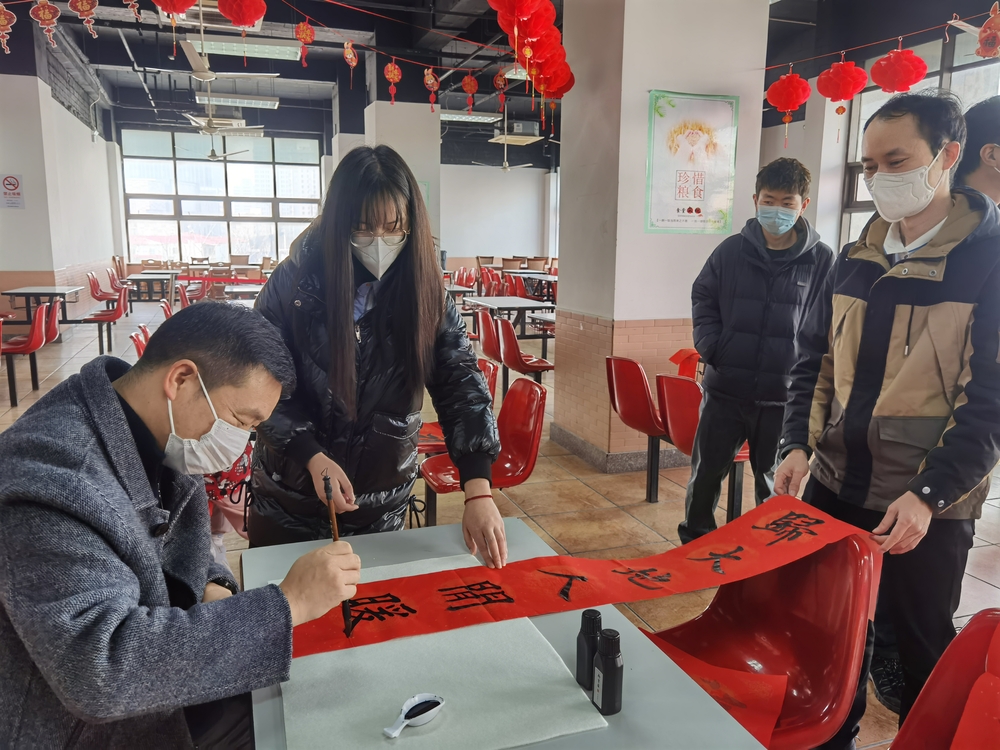 李志鹏与留校学生一起写春联.