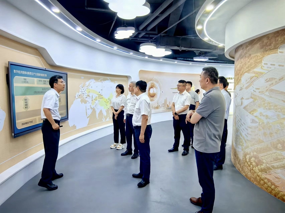 李启明（左一）介绍工作情况