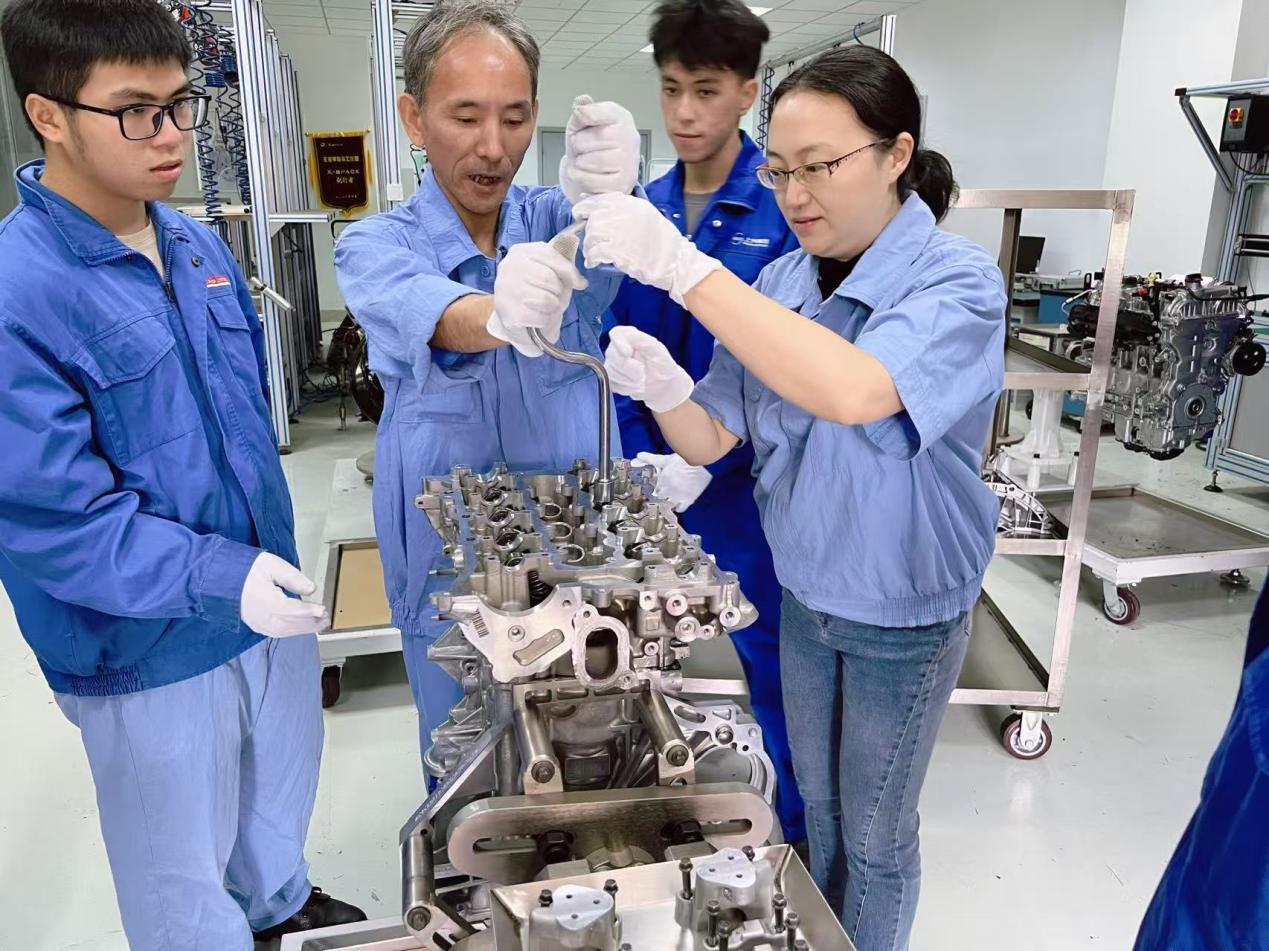 舒帆与企业导师一起指导学生拆装发动机