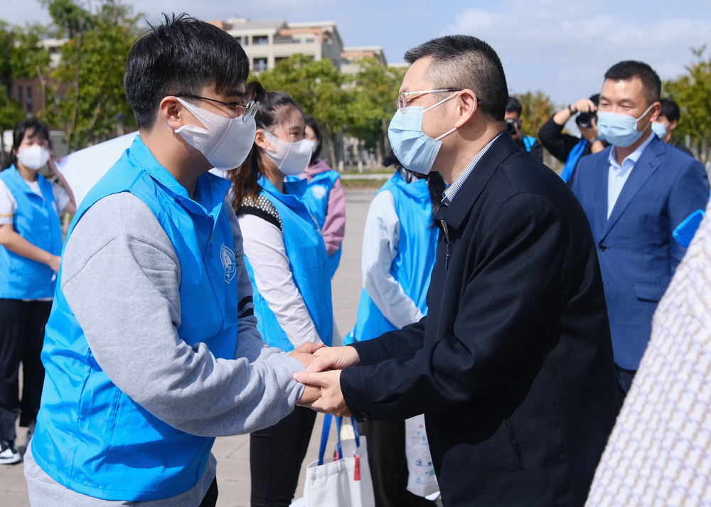 陆靖校长、李志鹏副校长为志愿者代表发放纪念品