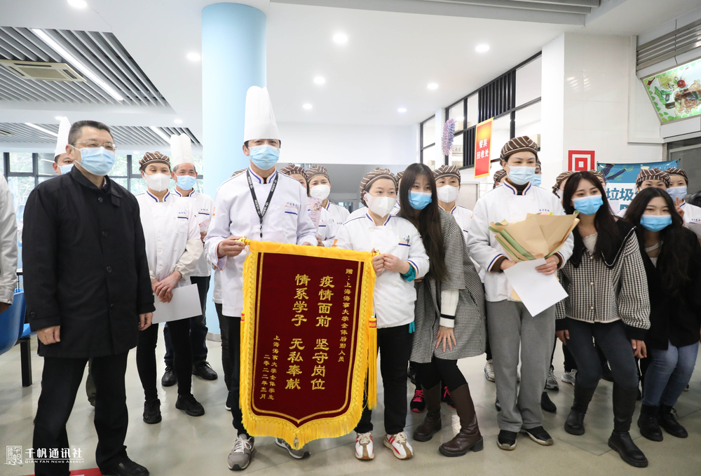 陆靖校长与同学代表一起向食堂工作人员送上鲜花和锦旗