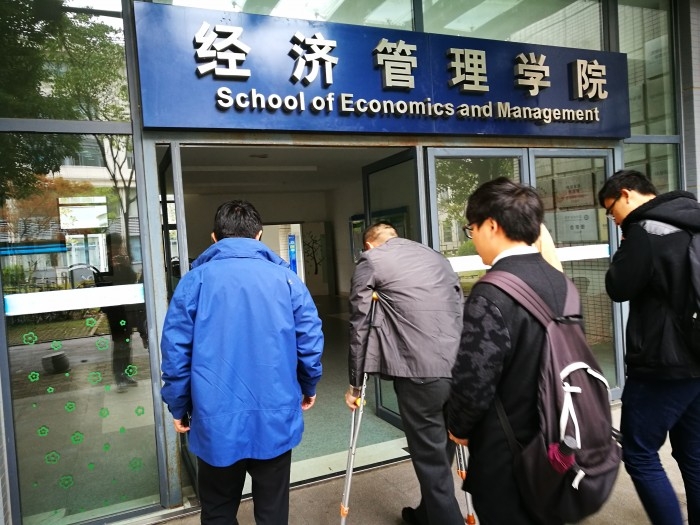 侯剑老师在学生帮助下上楼梯