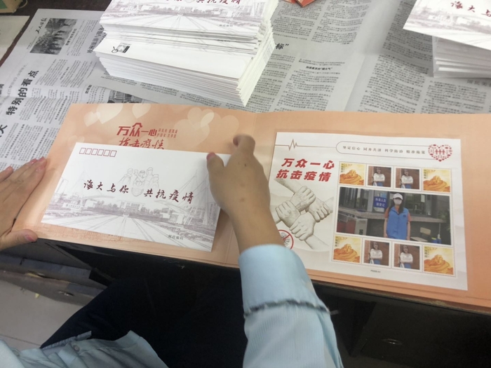 为参加志愿服务的教职工送上纪念册