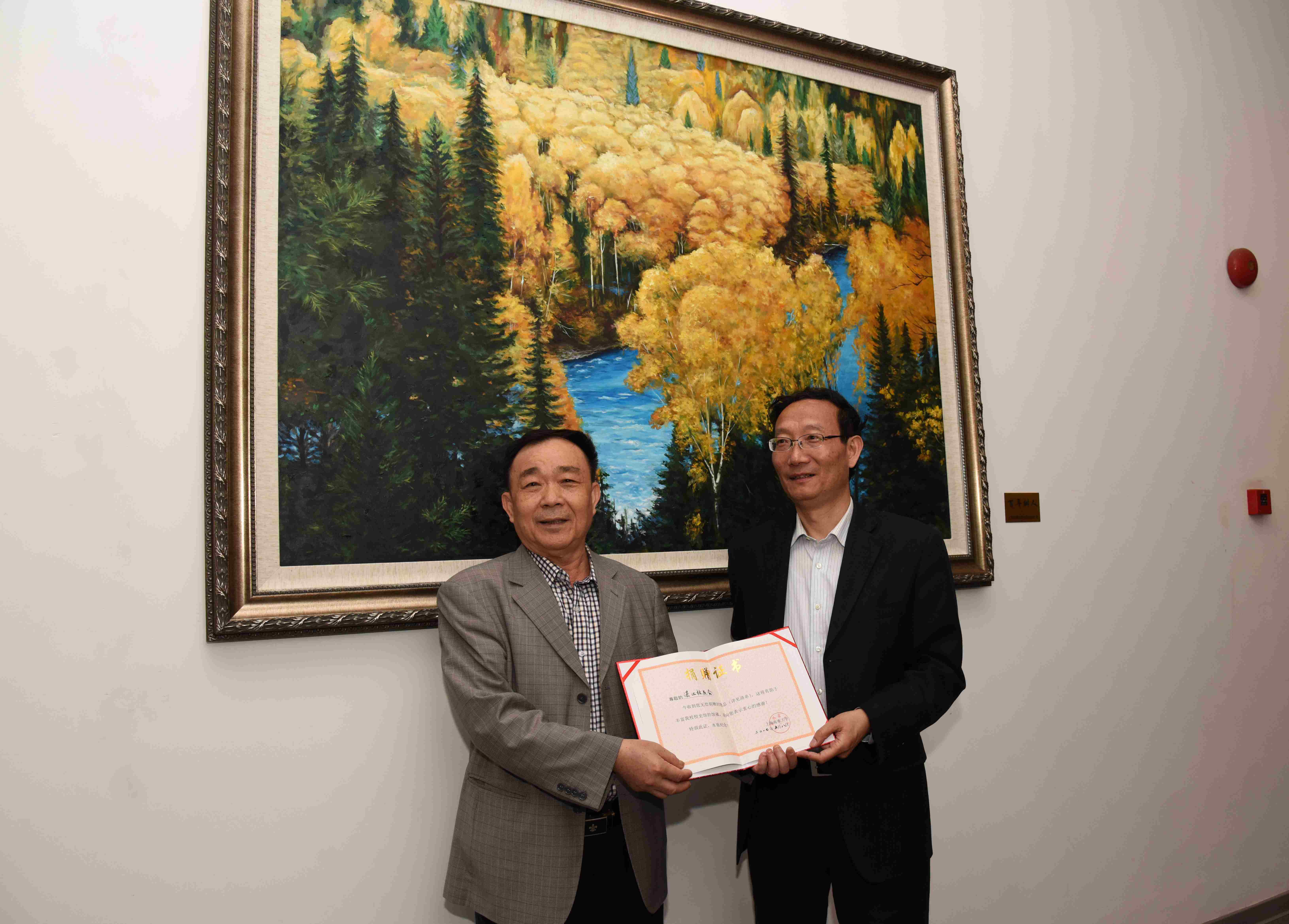 黄有方校长代表学校接受湛江校友会秘书长蔡法向母校捐赠的“百年树人”油画