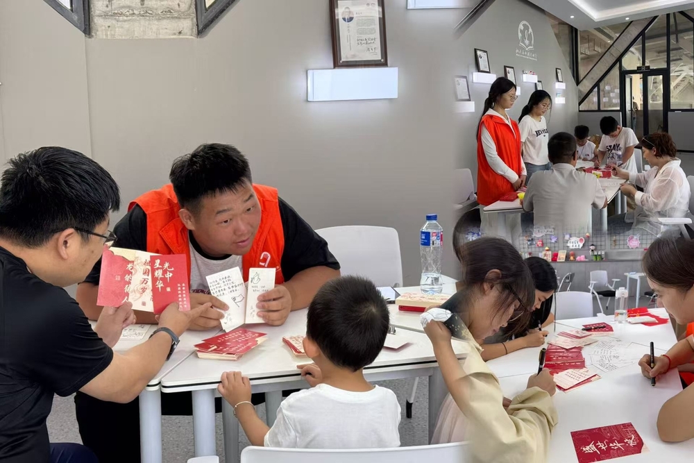 志愿者带领游客在明信片上书写对祖国的赞美与祝福