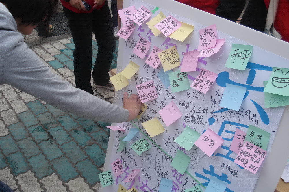 同学们与社区居民一起书写十八大寄语