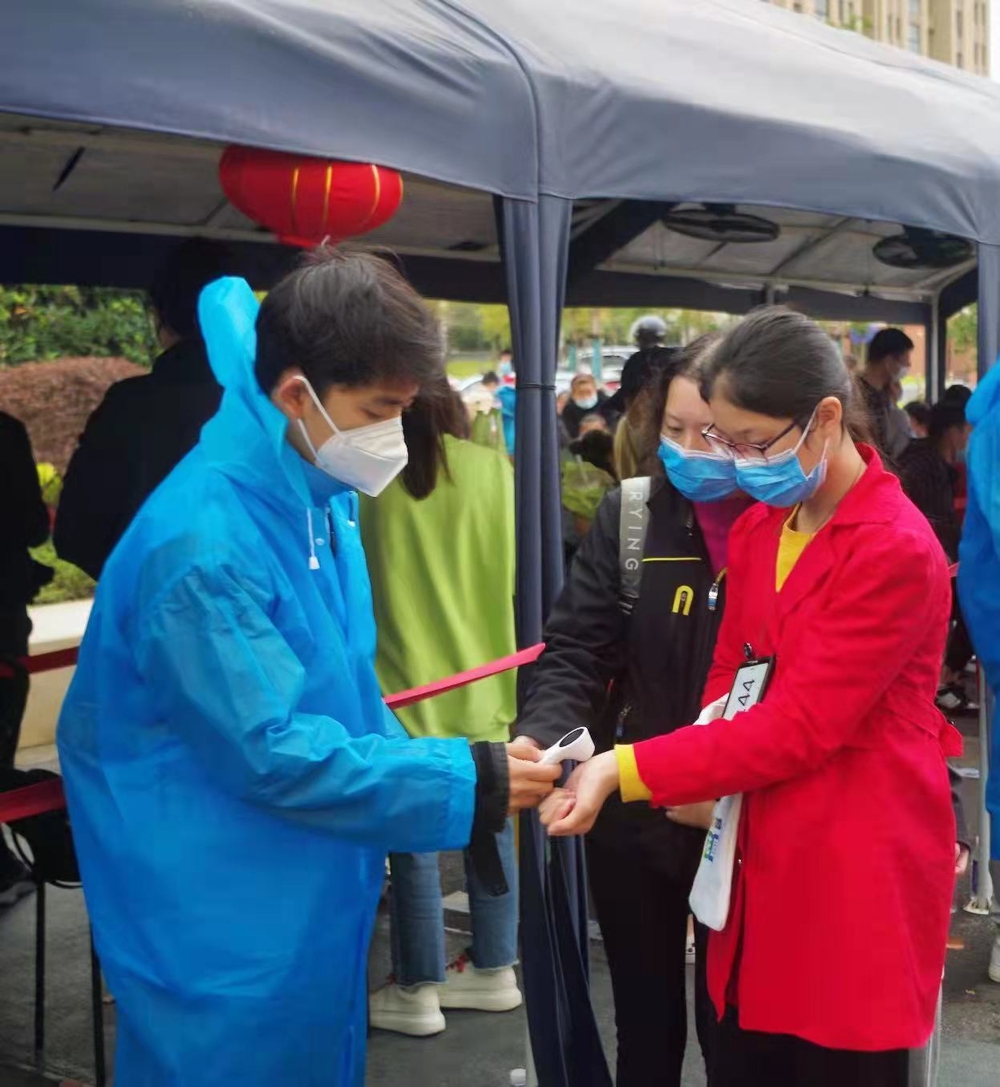 20211111001542484300.jpg 志愿者进行测量体温工作