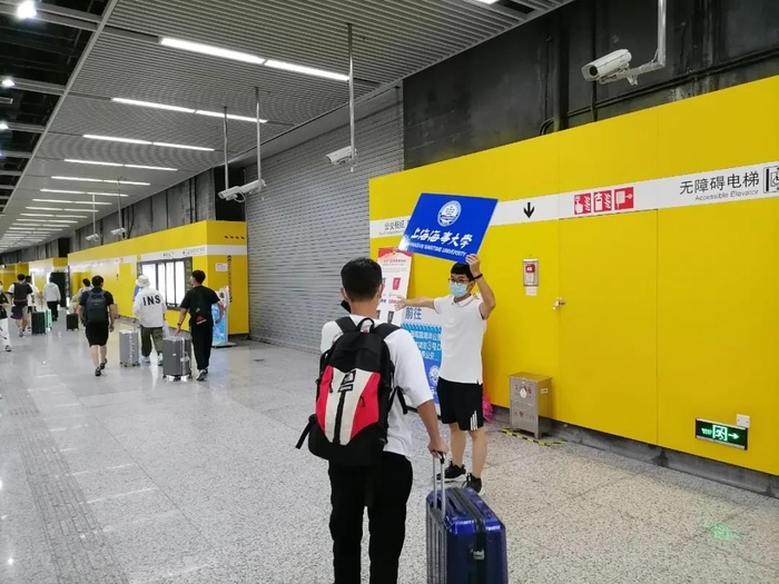 志愿者在临港大道地铁站迎新 