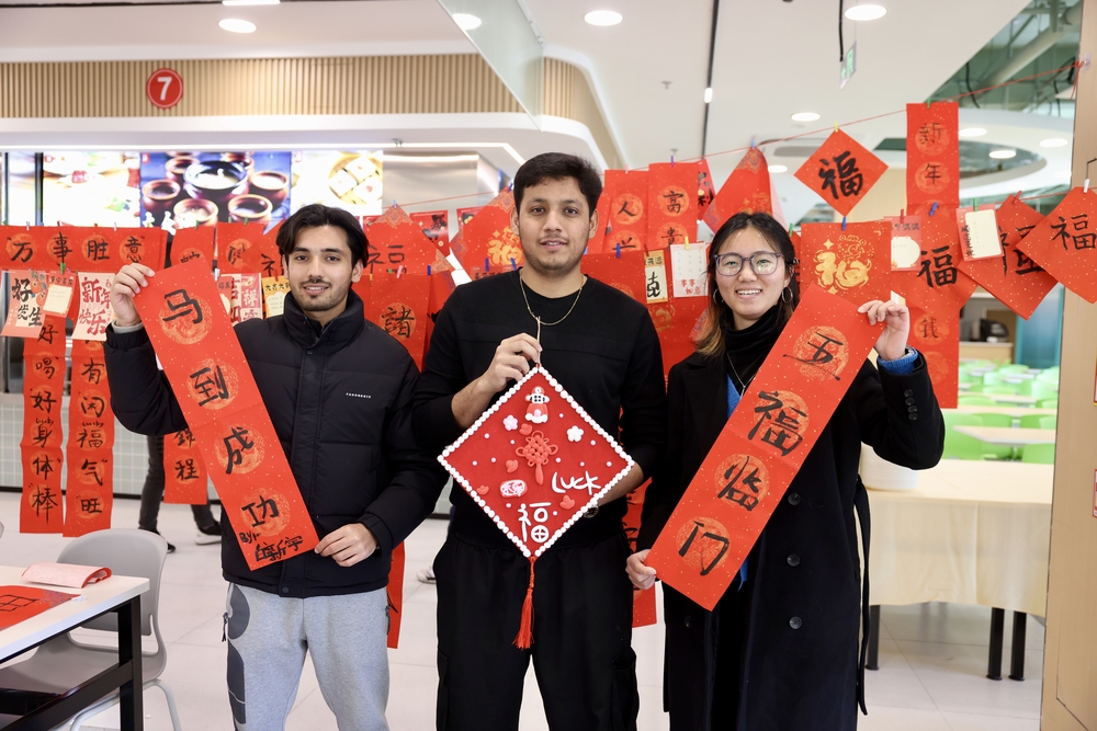 留校学生展示书写的春联、福字