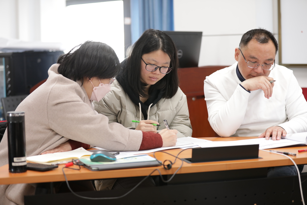 20250410104644513700.jpg 张琴(左一)与焦佳佳副教授(左二)在试点班培训现场研讨教学案例